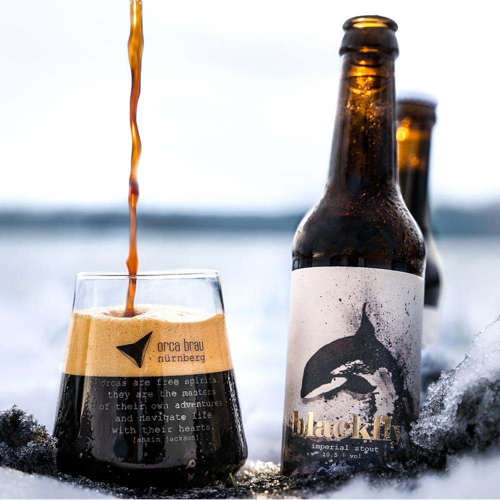 Das Bier Blackfly wird in einer winterlichen Landschaft eingeschenkt